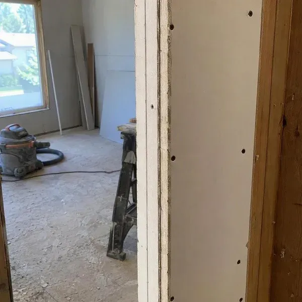 Double layer of soundproof drywall visible at a doorway edge