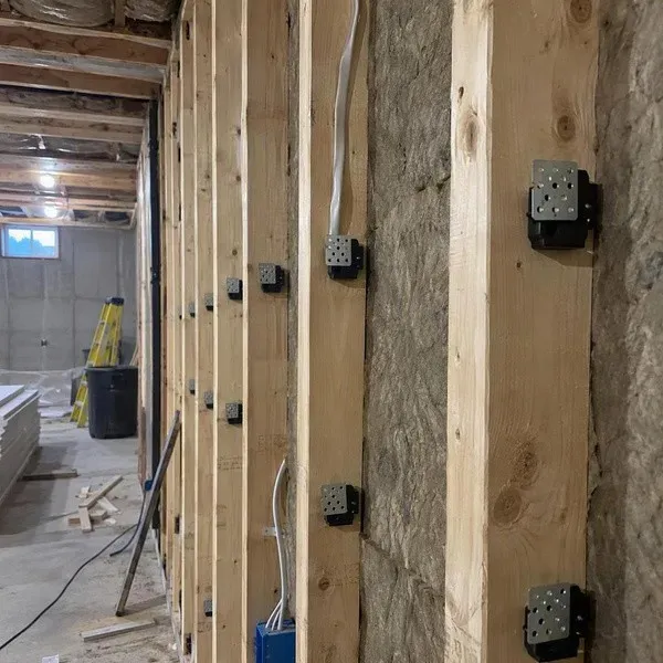 Sound isolation clips mounted on wall studs before hat channel and drywall