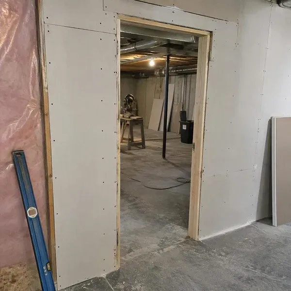 Soundproof drywall installed around a basement media room doorway