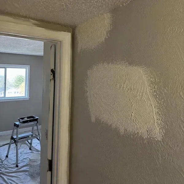 Textured wall repair drying beside a doorway in an older home